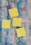Four yellow empty square stickers in the blue old wooden background