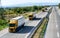 Four yellow Lorry trucks in line on a country highway