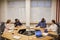 Four young contemporary experts sitting by round table during discussion