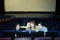 Four young friends sit on seats in cinema theater