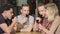 Four young people drink liquor at the bar