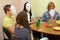 Four young people play Mafia with masks at the