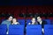 Four young people watch movie in cinema theater.