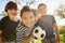 Four young schoolboys leaning in to camera holding football