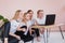 Four young sisters smile and look at monitor of laptop.