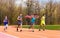 Four young sprinters waving American flag on track