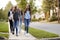 Four young teen girls walking to school together, front view