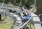 Fourteen year-old Amerasian boy enjoying a ride in a blue sled on a rollercoaster-like track in Vail, Colorado.