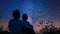 The fourth image captures a parent and child duo sitting outside at night gazing up at the stars. The parent points out