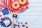 Fourth of July american Independence Day background decorated with USA flag, donut with candys, stars and confetti.