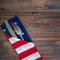 Fourth of July Table Place Setting with a fork, knife and flag napkin on rustic wood board background with room or space for copy,