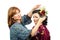 Fox-coloured hairstylist putting roses and butterfly in her hair