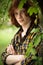 Foxy freckled guy looks at camera standing crossed hands. Red-haired young man with long hair wearing in a plaid shirt