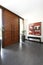 Foyer with wooden double doors with long vertical metal handles and an entry table and painting at the side