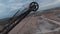 FPV drone flies maneuverable near rusty abandoned walking excavator