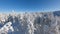 FPV drone flying close to the snow-covered trees in a winter forest.