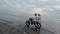 FPV sport drone follow flight around travel couple riding motorbike beach sand