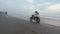 FPV sports drone follow travel couple riding motorbike on beach black sand