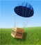 Fragile parcel on parachute flying in the air