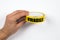 Fragile, yellow warning tape in a man& x27;s hands on a white background