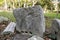 Fragment of the ancient carved stone block with an inscription in Greek. Antique artifact outdoors