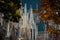 Fragment of beautiful gothic facade of Votivkirche church surrounded by colorful trees in autumn season in Vienna