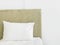 Fragment of bedroom interior in luxurious hotel bed with upholstered velour bedhead board white pillow pure cotton bed linen wall