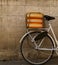 Fragment of a bicycle with decorative wheels on the trunk against the background of the wall on the street.