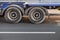 Fragment of big truck, wheels on dark asphalt road