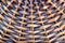 Fragment of the bottom of a wicker basket made of wooden rods. Brown textured