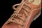 Fragment of brown mens shoe with shoelaces on dark background