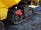 Fragment of a bulldozer with a tracked wheel littered with unpalatted road. Caterpillar on a paver.