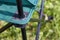 Fragment of a camping chair. Stands on the grass of a summer meadow