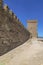 Fragment of a castle wall of a fortress fortification made of natural stone.