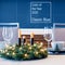 Fragment Christmas table setting with classic blue color accessories. Spruce wreath and stars garland, selective focus