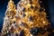 A fragment of a Christmas tree with toys and lights, yellow light shimmers and shines, a festive atmosphere