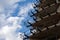 Fragment of concrete metal structures on a background of blue sky with clouds. Construction of a multi-level parking, residential