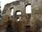 Fragment of destroyed ancient brick wall with windows. Ancient stone fortress wall ruins