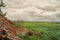 Fragment of the destroyed wall from agricultural buildings in the fields under the clouds.