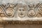 Fragment of the facade with the image of stone masks of the Greco-Roman amphitheater of the ancient city of Myra in Demre