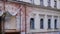 Fragment of facade with ruined windows and crumble stucco fretwork of an old abandoned building. Destroyed ancient building ready