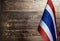 Fragment of the flag of the Kingdom of Thailand in the foreground blurred wooden background Kopi space