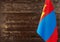 Fragment of the flag of Mongolia in the foreground blurred wooden background Kopi space