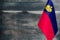 Fragment of the flag of the Principality of Liechtenstein in the foreground blurred wooden background place under the text