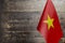 Fragment of the flag of the socialist Republic of Vietnam in the foreground blurred wooden background copy space
