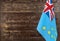 Fragment of the flag of Tuvalu Islands in the foreground blurred wooden background Kopi space