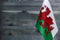 Fragment of the flag of Wales in the foreground blurred wooden background place under the text