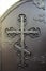 Fragment of a forged metal door with decoration in the form of an Orthodox cross. Black color. Religious design.Close-up.