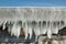 Fragment of a frozen breakwater wall with icicles