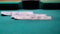 A fragment of a green billiard table, dollar bills are falling and balls are rolling out of focus. Selective focus